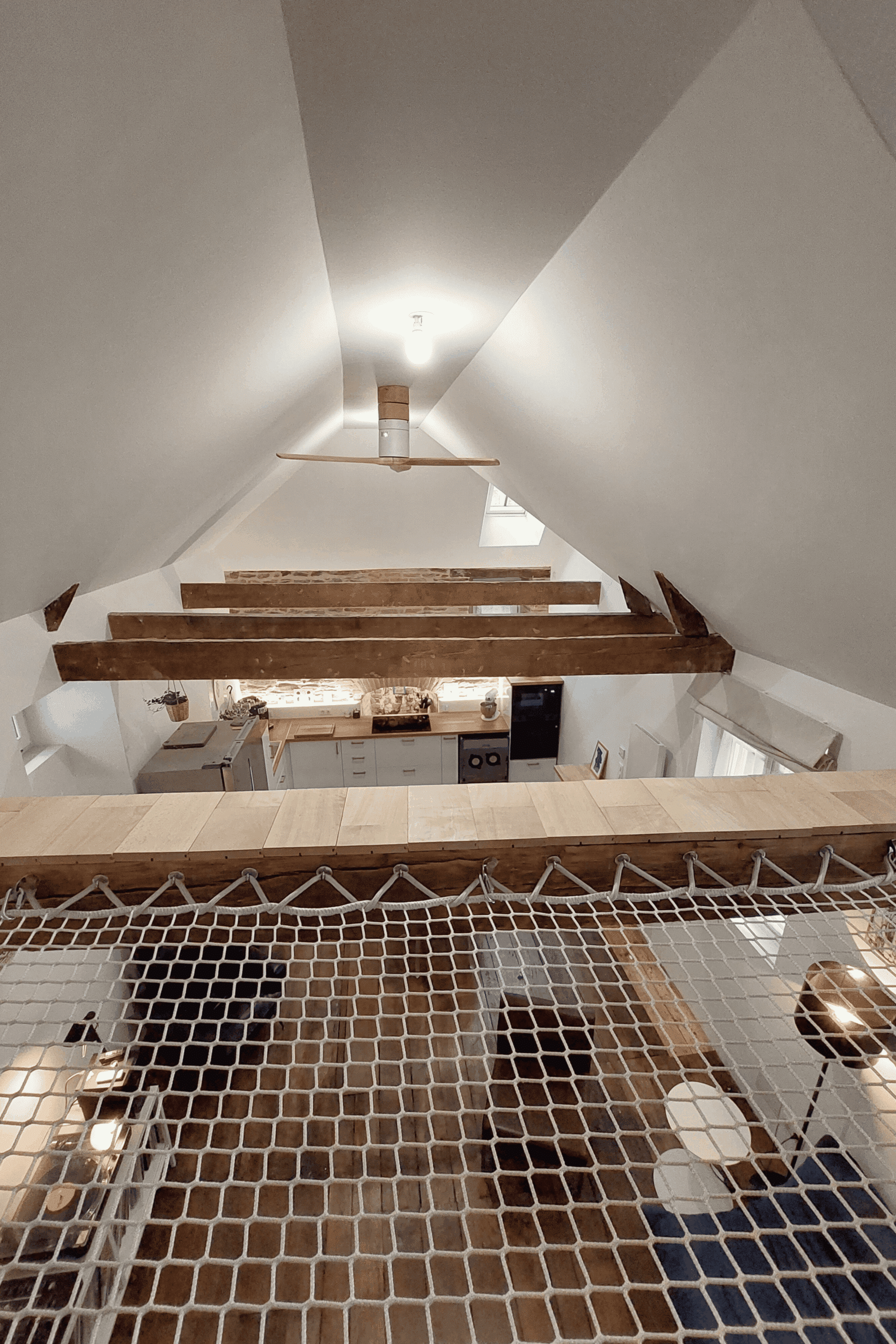 Filet suspendu dans un séjour en double hauteur, clin d’œil au stockage du foin d’origine